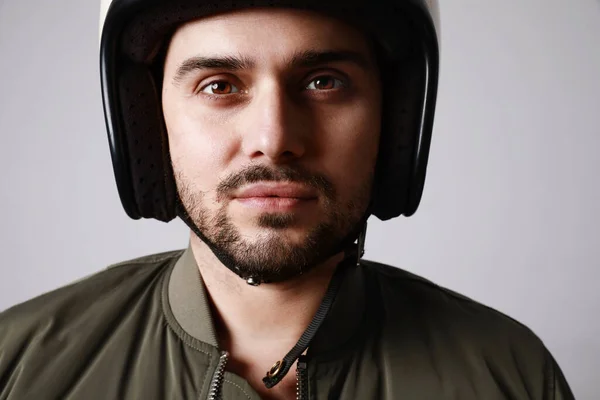 Primer plano de brutal barbudo motociclista hombre lleva casco y vestido con una chaqueta de bombardero verde. Espacio libre para texto . — Foto de Stock