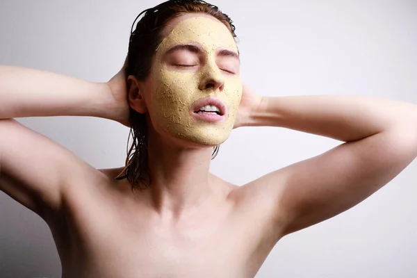 Mujer joven con mascarilla facial hidratante con ojos cerrados aislados sobre fondo gris. Belleza y cuidado de la piel concepto . —  Fotos de Stock