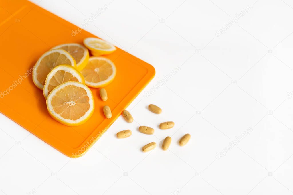 Slices of lemon lie on a cutting board. Nearby are Vitamins C. Health. The topic of increasing immunity