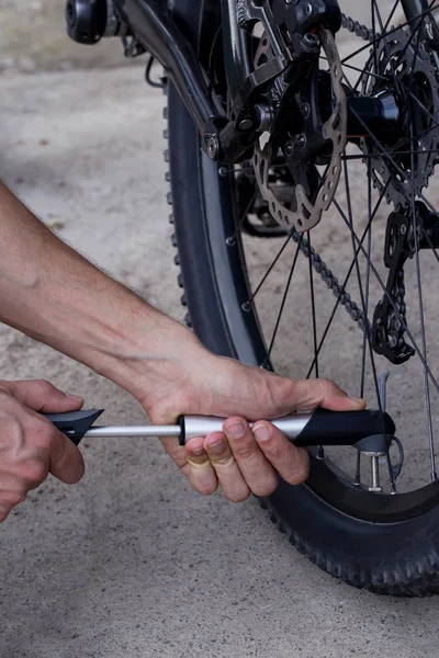 El joven infla rueda de bicicleta — Foto de Stock