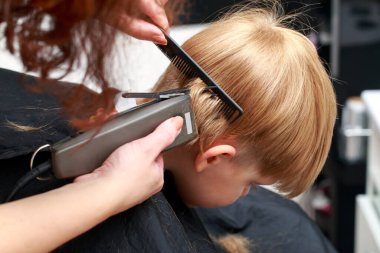 Berber dükkanındaki küçük çocuk bir profesyonel tarafından kesilmiş.