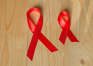 Farkındalık kırmızı kurdele ahşap arka plan üzerinde: AIDS, HIV ile Aralık ayında yaşayan insan sağlığı için genel destek için promosyonlar karşı dünya gün mücadele