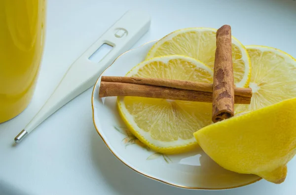 Šálek čaje, teploměr a citronem se skořicí - lék na nachlazení — Stock fotografie