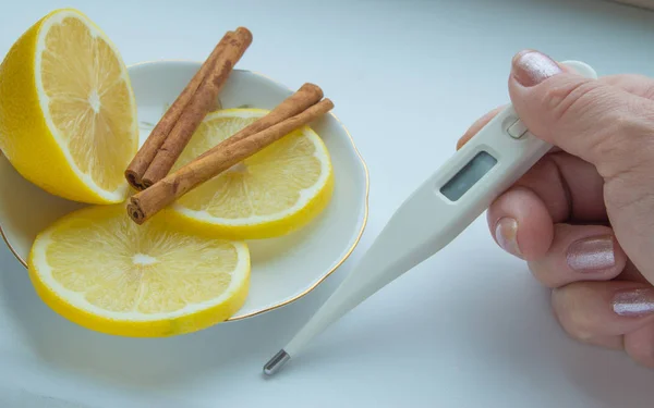 Das Thermometer in den Händen, Tabletten, Zitrone mit Zimtbehandlung — Stockfoto