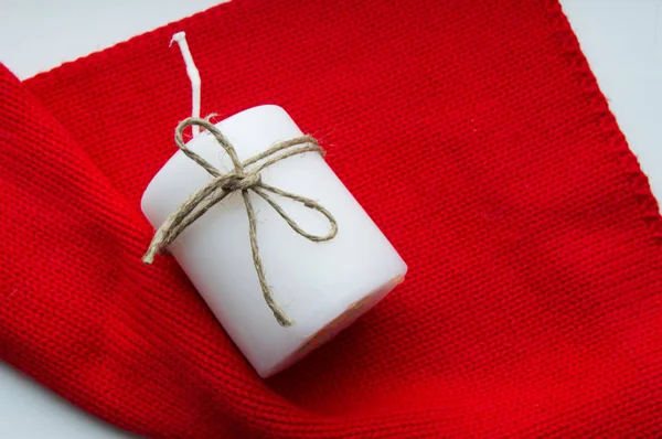 Bufanda roja de Navidad y una vela blanca, atada con cordel, espacio para copiar. Tiempo de Navidad — Foto de Stock