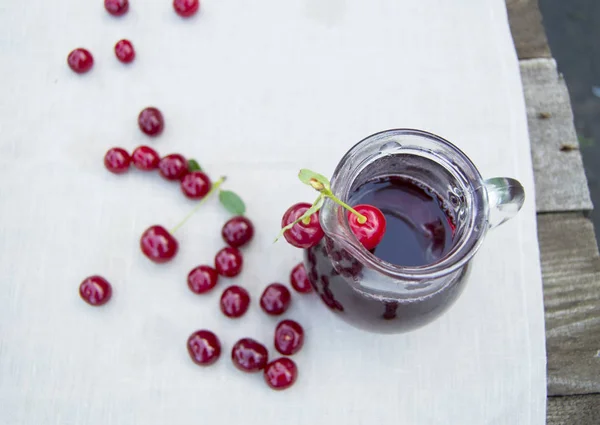 Koude kersensap in jar en rijpe bessen, selectieve aandacht — Stockfoto