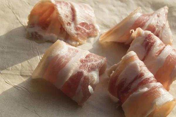 Szelet bacon gördült be a tekercseket a pergamen — Stock Fotó