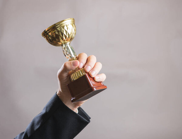 Hand of businessman holding Cup, concept success