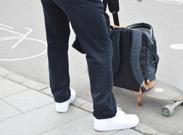 Skateboarder βάζει τα πράγματα στο σακίδιό με το skateboard. Η έννοια του σπορ τρόπο ζωής — Φωτογραφία Αρχείου