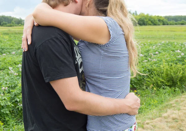 Gli amanti uomo e donna che si abbracciano su uno sfondo di erba — Foto Stock