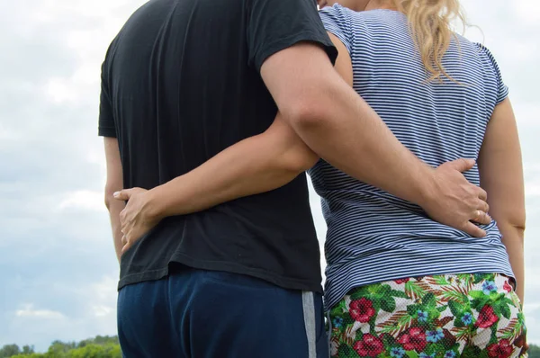 Amantes hombre y mujer abrazándose sobre un fondo de hierba —  Fotos de Stock