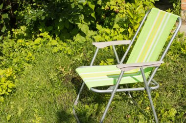 Yeşil çimenlerin üzerinde kamp için katlanır sandalye