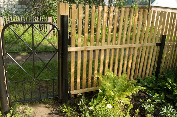 Nieuwe piket hek en zwarte metalen poort voor bescherming en veiligheid in de tuin — Stockfoto