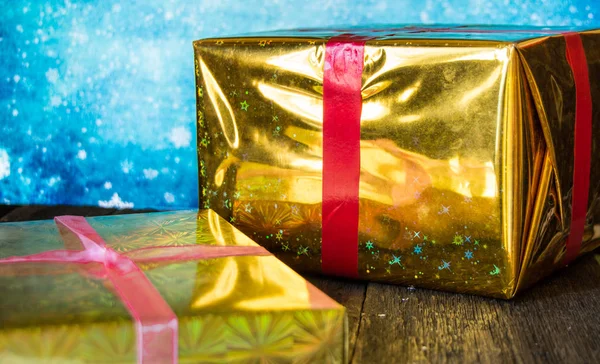 Dvě lesklé dárkové krabice k Vánocům na modrém pozadí — Stock fotografie