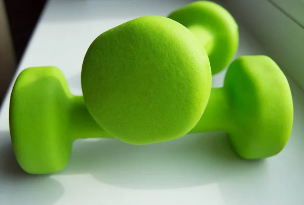 O conceito de aptidão física, um estilo de vida são - dois halteres verdes de esportes — Fotografia de Stock