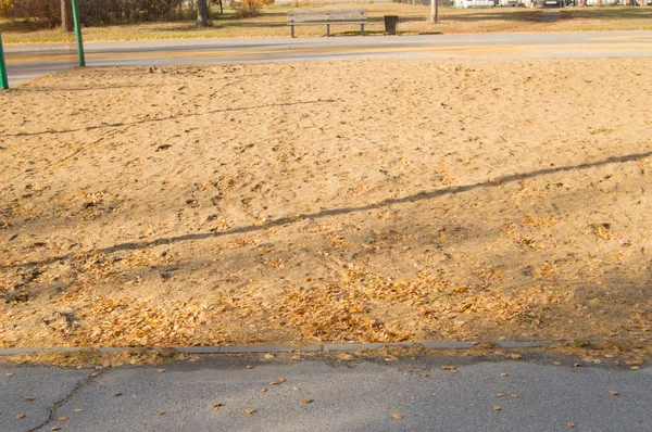 Hojas caídas en la arena Parque infantil para el voleibol en el Parque — Foto de Stock