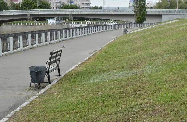 Набережна в центрі міста, пішохідна доріжка і лавка — стокове фото