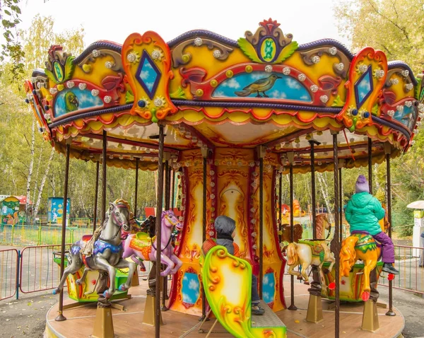 Çocuklar Park renkli atlıkarında atlara binmek