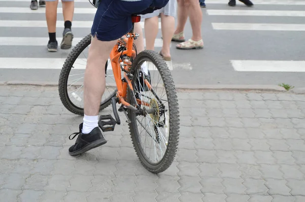 Αρσενικό ποδηλάτης καθισμένος επάνω στο ποδήλατο, αναμένει το πέρασμα σε μια διάβαση πεζών — Φωτογραφία Αρχείου