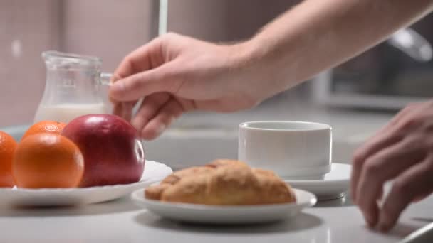 Így reggeli, forró kávét tejjel, egy kancsó, croissant, Alma keze — Stock videók