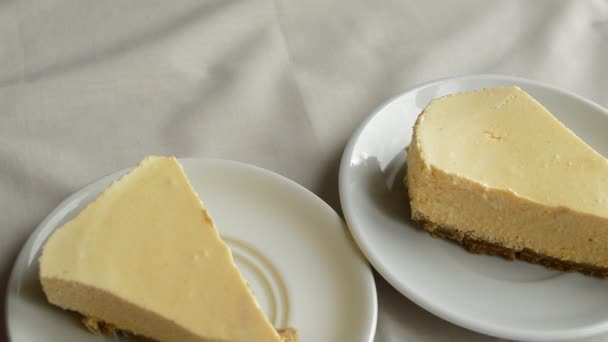 Copa blanca de café y un pastel de queso, poner a una mujer sobre la mesa, sabroso desayuno — Vídeos de Stock