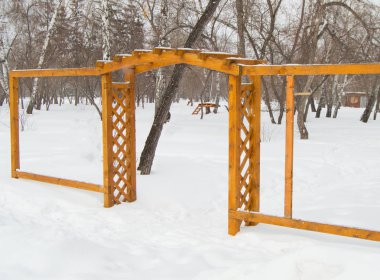 Kış, bulutlu gün ve kar Park ızgara ile ahşap kemer