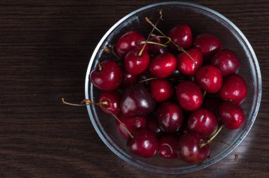 Koyu arka plan, üstten görünüm üzerinde kase taze tatlı kiraz