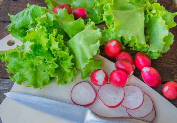 Rzodkiewki i świeżej sałaty organicznych na ciemnym tle drewnianych — Zdjęcie stockowe