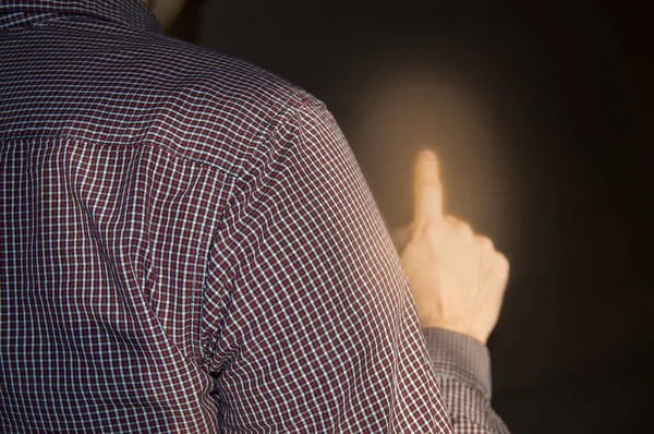 Index finger raised up, man shows gesture of attention, touch, point, back view