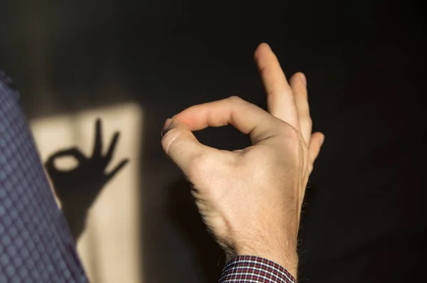 Людина жестикулює добре знак на стіні тінь руки — стокове фото