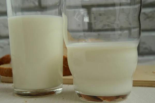 Dois copos de leite estão sobre a mesa, Café da manhã para a família, conceito de alimentação saudável, dia mundial da saúde — Fotografia de Stock
