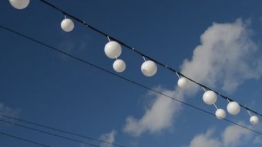 Rüzgara karşı mavi gökyüzü ve bulutlar, huzurlu manzara içinde beyaz garland balonlar salınım