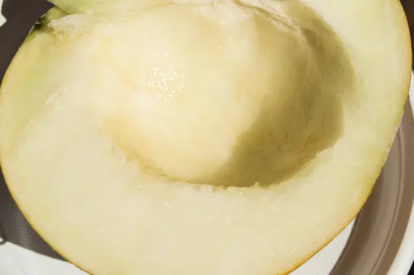 Medio rebanado jugoso melón de naranja poner en un plato — Foto de Stock