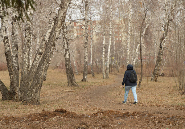 Нордическая ходьба для потери веса. Взрослая женщина занимается пешим туризмом в городском парке для активного и здорового образа жизни
