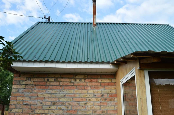 Bir ev ile yeşil siding kaplı metal bir çatı inşaatı