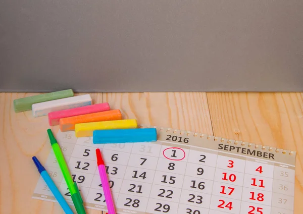 Voltar à escola, calendário, giz colorido em fundo de madeira — Fotografia de Stock
