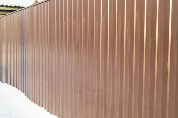 Clôture de revêtement ondulé en métal brun moderne, espace d'hiver extérieur, sécurité et sûreté, texture de placage — Photo