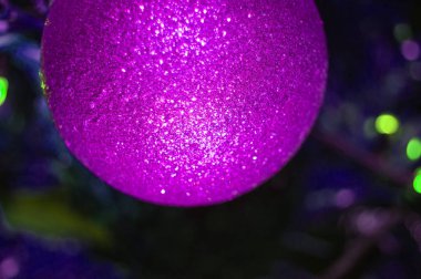 Parlak bir Noel balosu, yeşil bir Noel ağacının bulanık arka planında, çerçevedeki topun bir parçası, açık çerçeve, yakın çekim