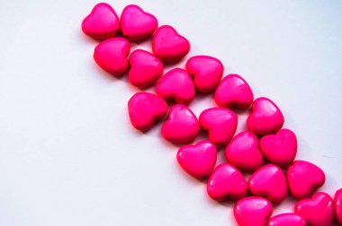 Kalp şeklinde kırmızı boncukların köşegen çizgisi beyazda izole edilmiş, Sevgililer Günü.