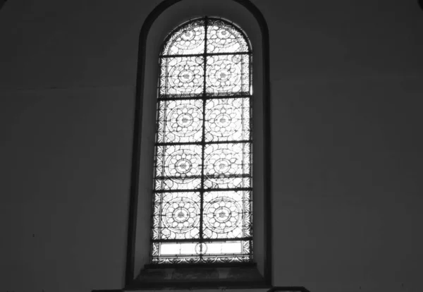 教堂里的彩色玻璃与天主教大教堂内部的黑墙相对照的黑白照片 — 图库照片