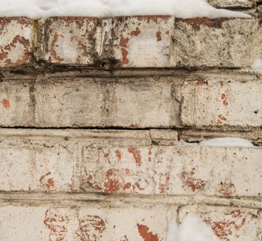 Eski tuğla işçiliğinde çatlak beyaz alçı, yakın plan, metin için yeri olan grunge tuğla duvar