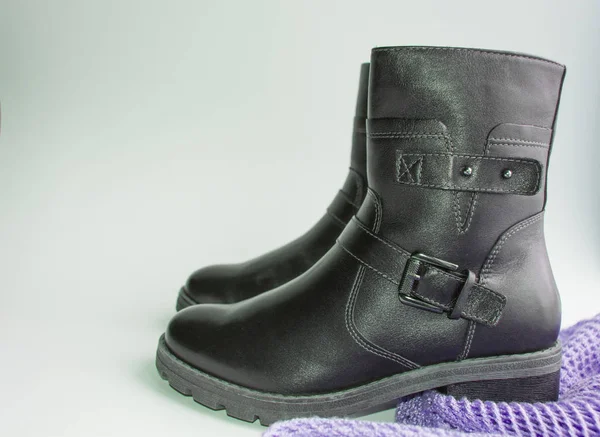 Moda invierno zapatos de mujer botas de cuero negro y sombrero de lana de punto sobre un fondo blanco, el concepto de comprar ropa de abrigo y zapatos para el invierno — Foto de Stock