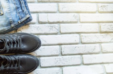 Erkeklerin sonbahar ve kış kıyafetleri beyaz tuğladan bir duvara yaslanıyordu.