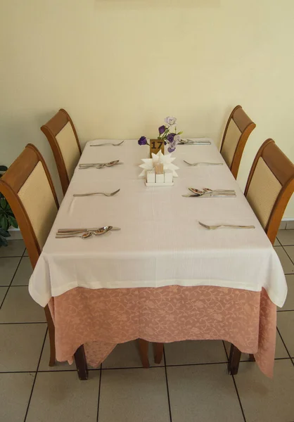 Festtafel mit Tischdecke und Besteck im Hotelrestaurant wartet auf Gäste, vertikale Aufnahme, Seitenansicht — Stockfoto