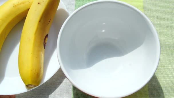 Солодкі Шоколадні Пластівці Наливають Білу Миску Поживний Сніданок Поруч Тарілкою — стокове відео