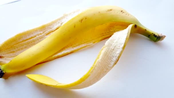 Bananenschale Auf Weißem Hintergrund Mit Hellem Sonnenlicht — Stockvideo