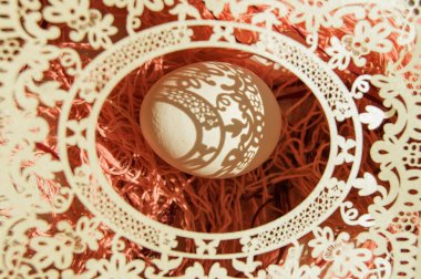 Beyaz bir Paskalya yumurtasının pembe arka planda, kağıt bir açılış çerçevesinde üst görüntüsü. Düz lei, aydınlıktan karanlığa desenli, parlak güneş ışığı