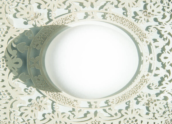 Top view of a white Easter egg in a paper openwork frame on a pink background. Flat lei with light-to-dark pattern, the bright sunlight