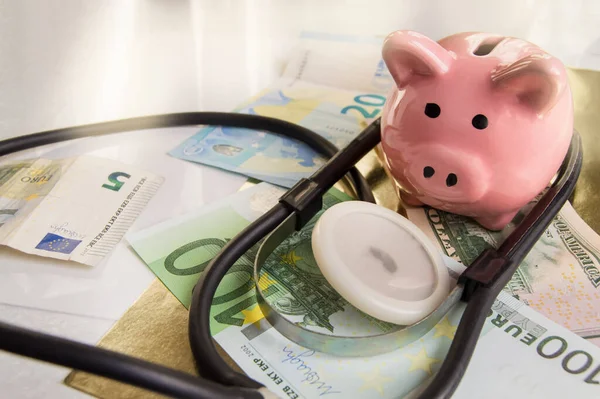 Funny piggybank, standing on dollars and euros with a phonendoscope. Saving hospital savings and investing in medicine, a healthy lifestyle.