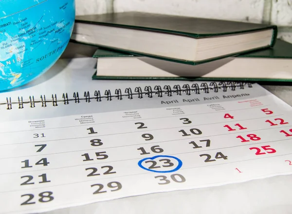 World book day, a calendar with a marked date of April 23, 2020, a stack of books and a globe.